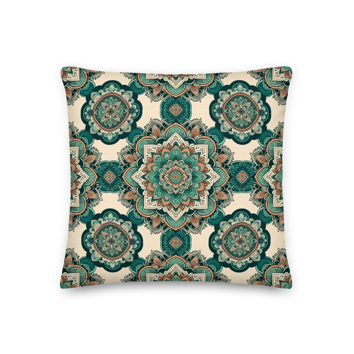 A decorative pillow with intricate mandala designs in shades of green, teal, and earthy tones, set against a light background.