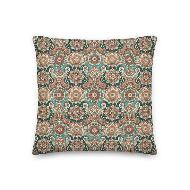 A decorative pillow with an intricate paisley and mandala pattern in muted turquoise, brown, and cream hues, set against a light background.