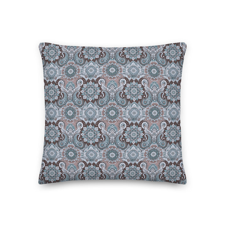 A decorative pillow with an intricate paisley and mandala pattern in soothing blue, gray, and taupe hues