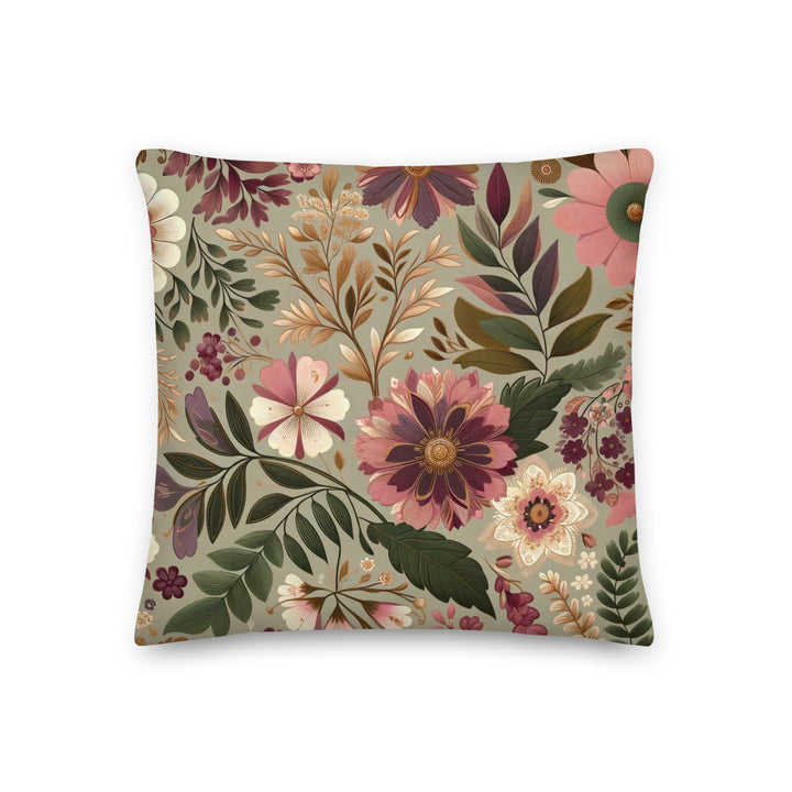 A decorative pillow with a beautiful floral pattern featuring various flowers and leaves in muted pink, purple, and green hues