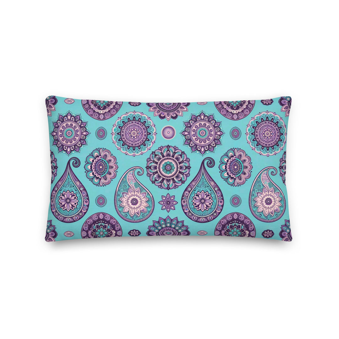 A decorative pillow with an intricate paisley and mandala pattern in shades of lavender, purple, and turquoise on a light turquoise background.