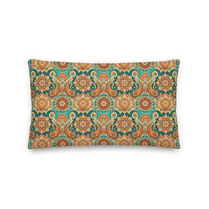 A decorative pillow with an intricate paisley and mandala pattern in vibrant hues of turquoise, orange, and gold, set against a light background.