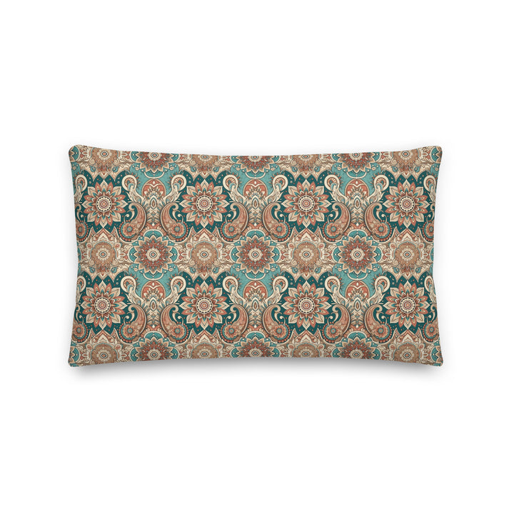 A decorative pillow with an intricate paisley and mandala pattern in muted turquoise, brown, and cream hues, set against a light background.