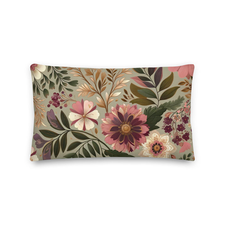 A decorative pillow with a beautiful floral pattern featuring various flowers and leaves in muted pink, purple, and green hues