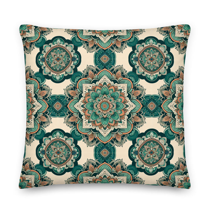 A decorative pillow with intricate mandala designs in shades of green, teal, and earthy tones, set against a light background.