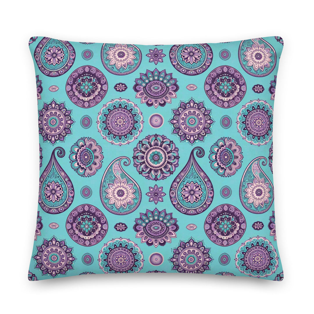 A decorative pillow with an intricate paisley and mandala pattern in shades of lavender, purple, and turquoise on a light turquoise background.