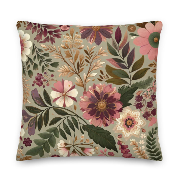 A decorative pillow with a beautiful floral pattern featuring various flowers and leaves in muted pink, purple, and green hues