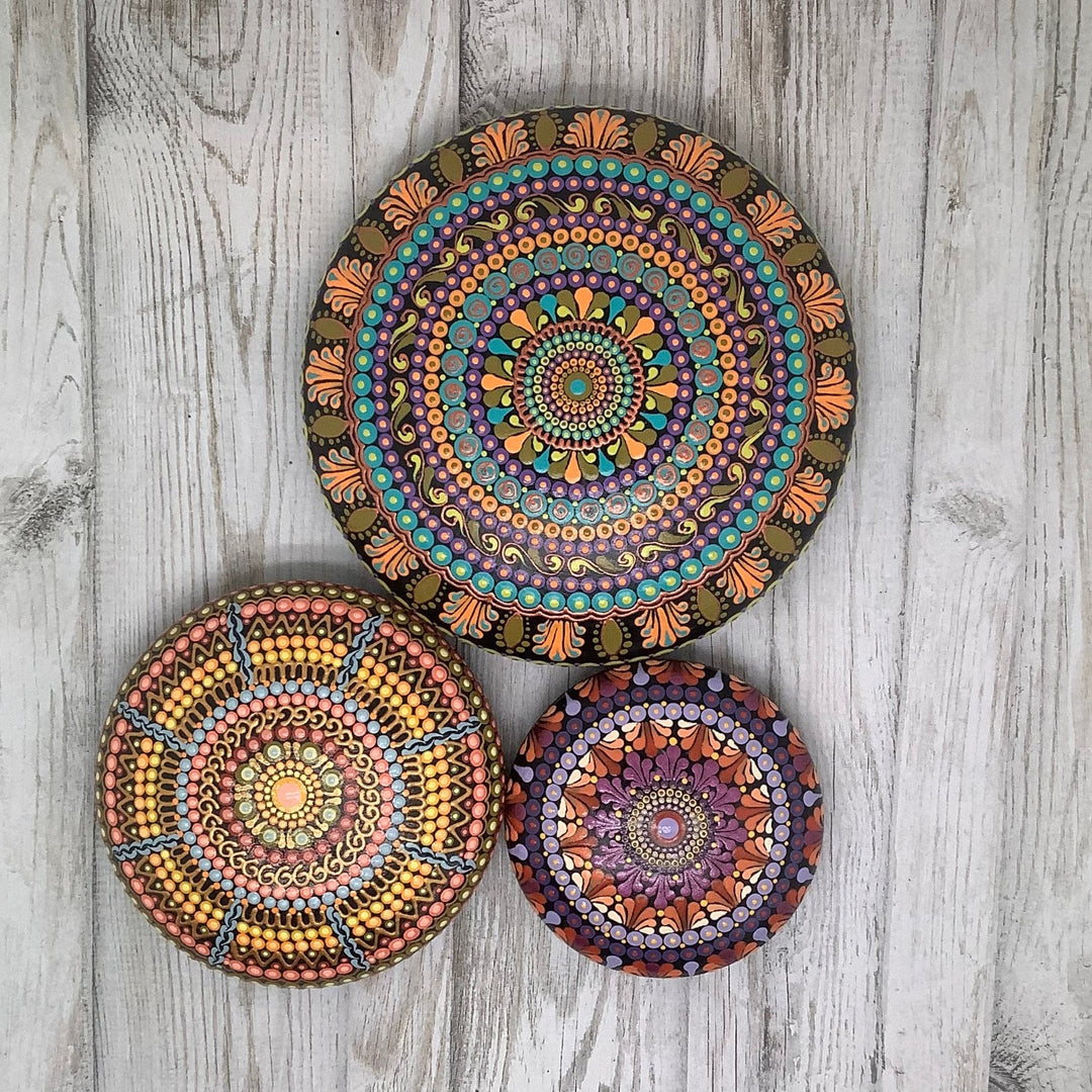 three mandala stones on a wooden table