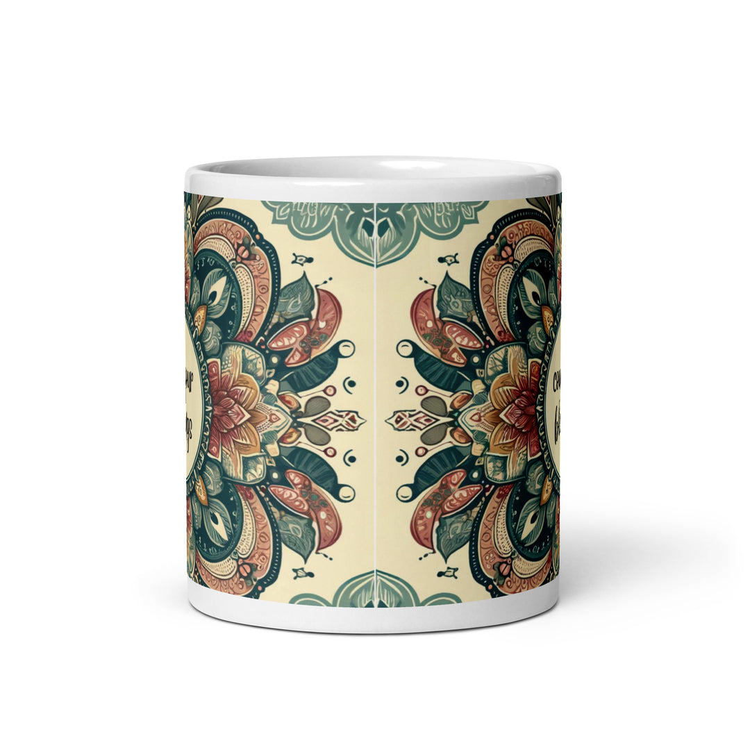 White ceramic mug with a detailed green, red, and gold mandala design and the phrase 'Count Your Blessings' in the center.