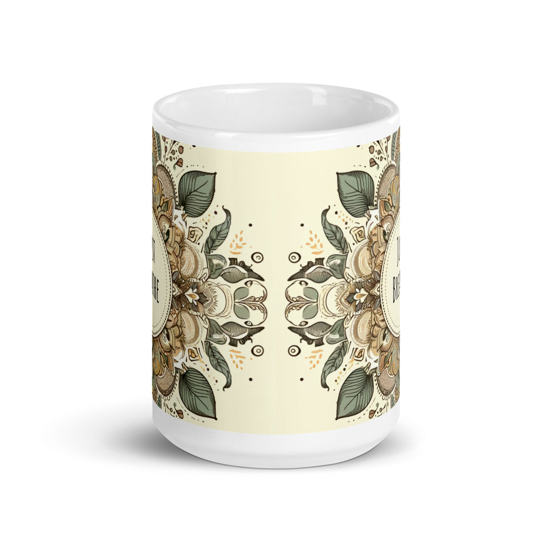 A white glossy mug with an intricate mandala design in earthy tones and the text 'Just Breathe' in the center.