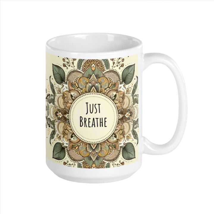 A white glossy mug with an intricate mandala design in earthy tones and the text 'Just Breathe' in the center.